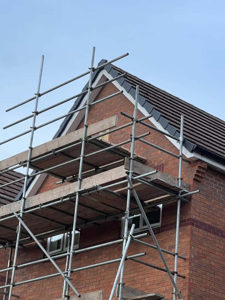 This is a photo of a roof which has just been repaired. There is a scaffold located at the gable end for access onto the roof. Works carried out by Petersfield Roofing Repairs