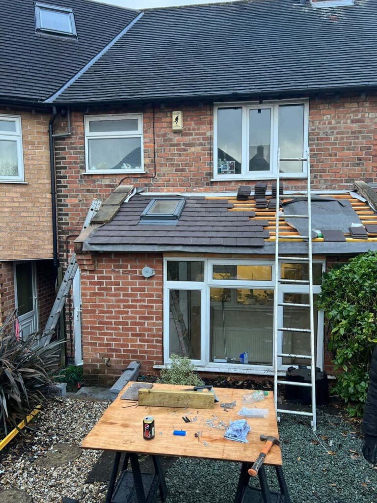 This is a photo of a roof extension that is having new roof tiles installed. This is a photo taken from the roof ridge looking down a tiled pitched roof on to a flat roof. Works carried out by Petersfield Roofing Repairs