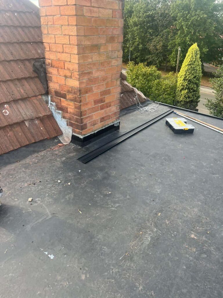 This is a photo of a flat roof which has just been repaired, there is also a chimney stack and some leadwork has also been dressed. Works carried out by Petersfield Roofing Repairs