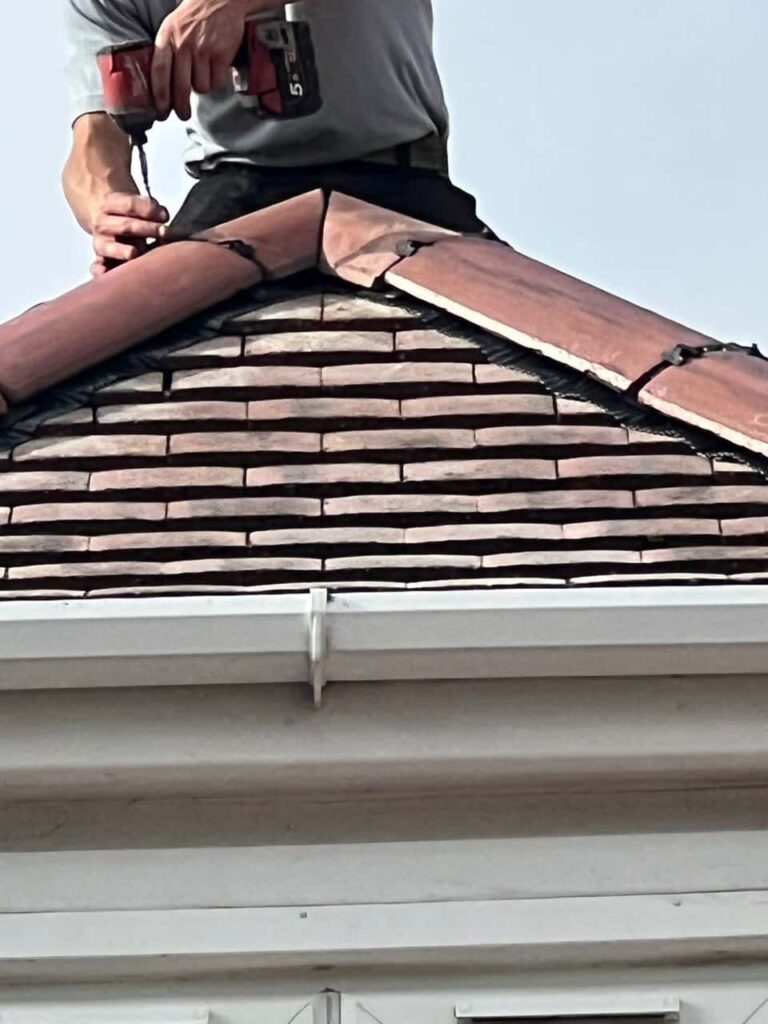 This is a photo of one of the operatives of Petersfield Roofing Repairs installing new ridge tiles